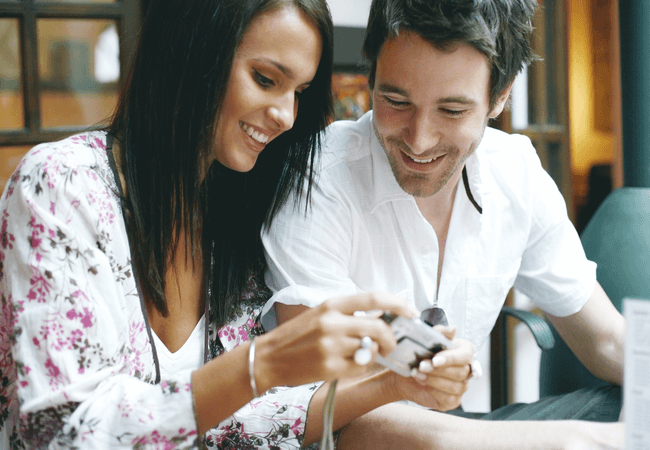 a man and a woman looking at pictures together and enjoying each others company