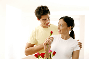 a man offering flowers to his girlfriend to show his love and commitment