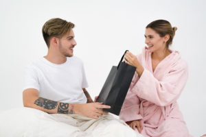 a woman giving a man a gift