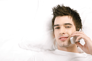 a man seductively talking to a woman on the phone while laying in bed